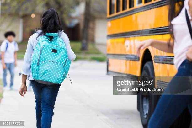 middle schoolgirl walks home after getting off of school bus - last day of school stock pictures, royalty-free photos & images