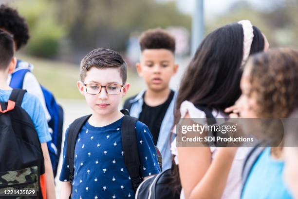 ongerust gemaakte basisschooljongen - alone in a crowd sad stockfoto's en -beelden