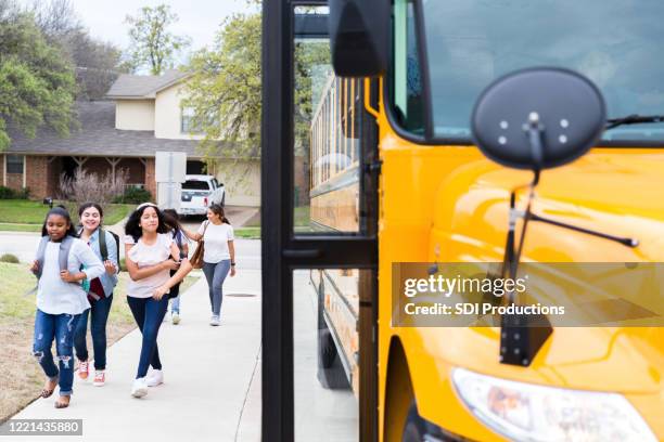 students walking to school bus stop - school district stock pictures, royalty-free photos & images