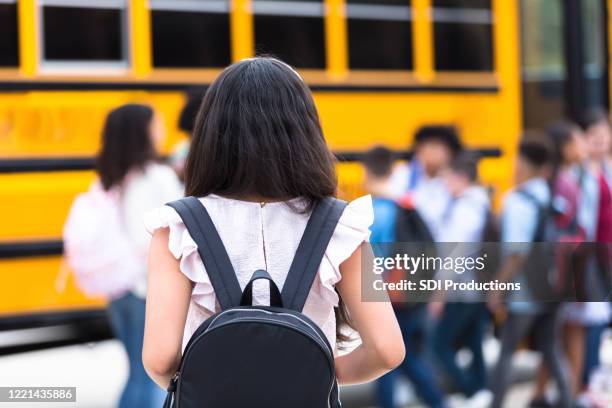 rear view of girl walking to school bus - peer pressure stock pictures, royalty-free photos & images