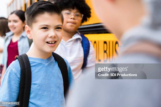 schoolboy talking with friend - peer pressure stock pictures, royalty-free photos & images
