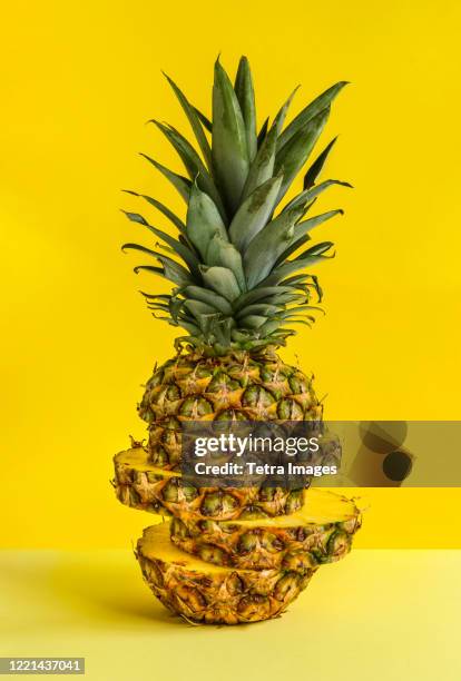 sliced pineapple against yellow background - パイナップル ストックフォトと画像