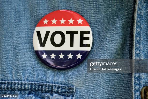 vote button on denim jacket - blue jacket stock pictures, royalty-free photos & images