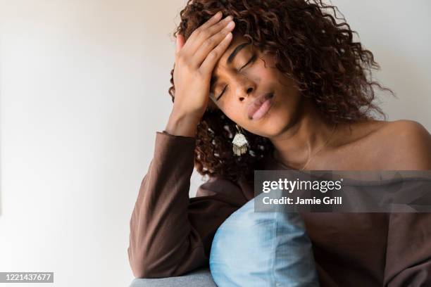 woman with headache holding her head - brun blus bildbanksfoton och bilder