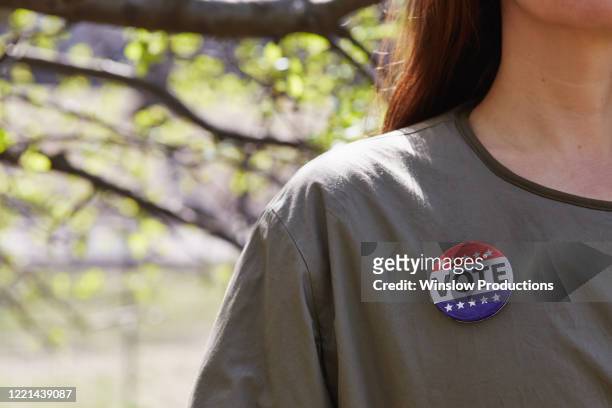 woman with vote button on her top - 競選運動鈕章 個照片及圖片檔