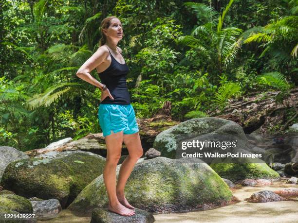 woman standing on rock in forest - daintree australia stock pictures, royalty-free photos & images