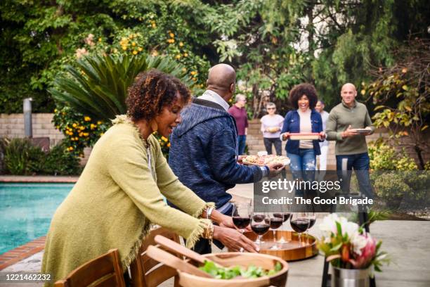 mature woman preparing for outdoor dinner party - the party arrivals stock pictures, royalty-free photos & images