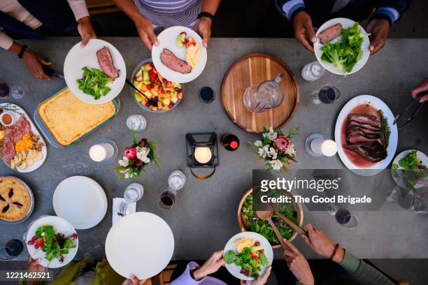 overhead view of friends eating dinner outdoors - plate eating table imagens e fotografias de stock