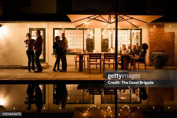 mature couples dancing by swimming pool at night - gartenschirm stock-fotos und bilder