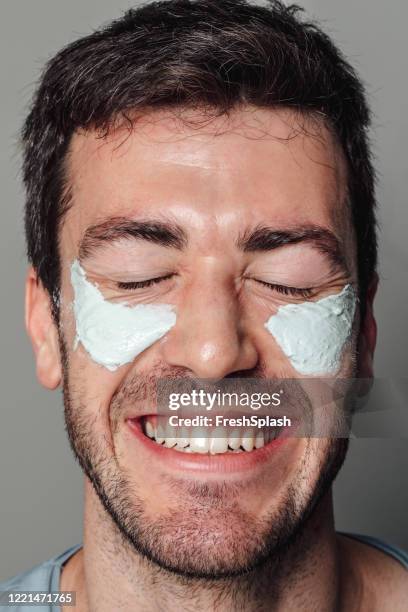skin care routine: face of a handsome man with a hydrating facial mask applied to it, a close up - man eye cream stock pictures, royalty-free photos & images