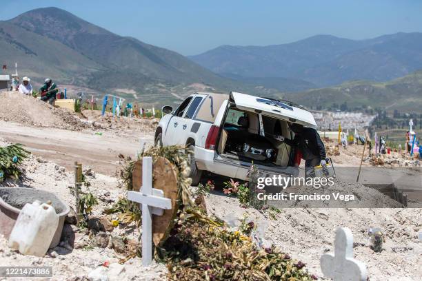 Cemetery worker wearing PPE disinfects a van after a burial of a COVID-19 victim at Panteon número 13 on April 27, 2020 in Tijuana, Mexico. Baja...