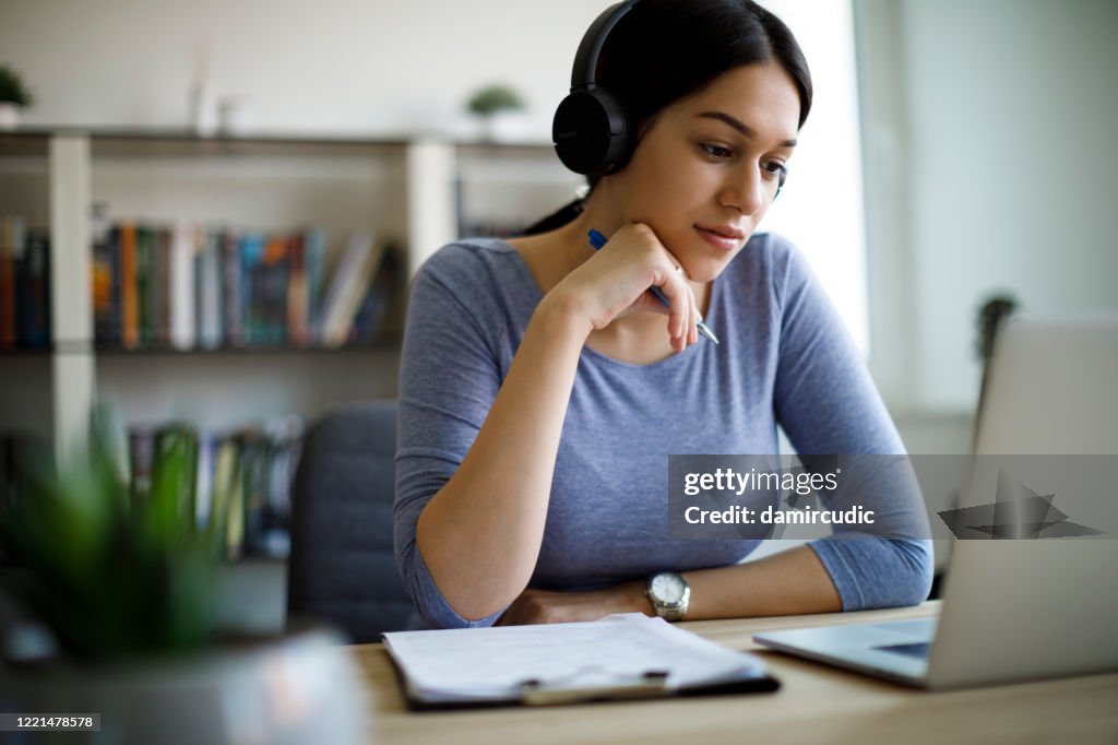 Young woman with headphones working from home