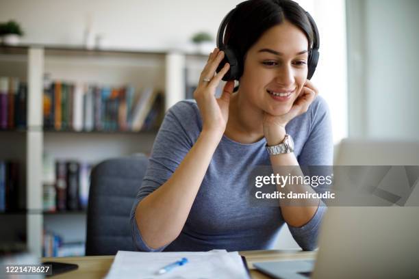 young woman with headphones working from home - online course stock pictures, royalty-free photos & images