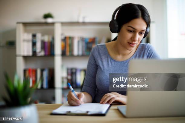 mujer joven que trabaja desde casa - web fotografías e imágenes de stock