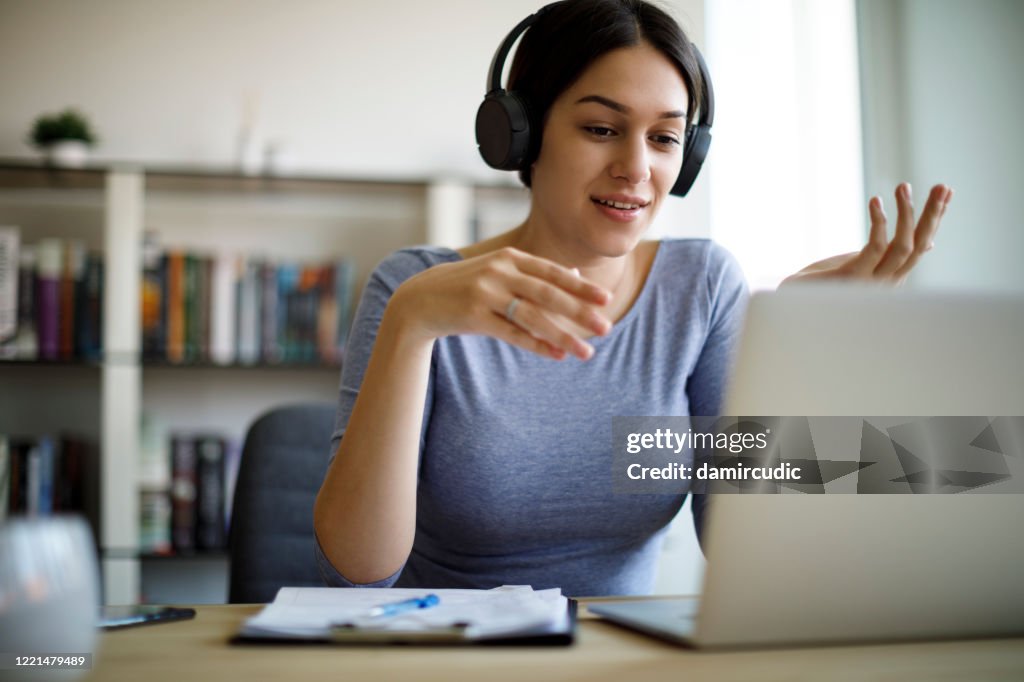 Young woman having video call on laptop computer at home