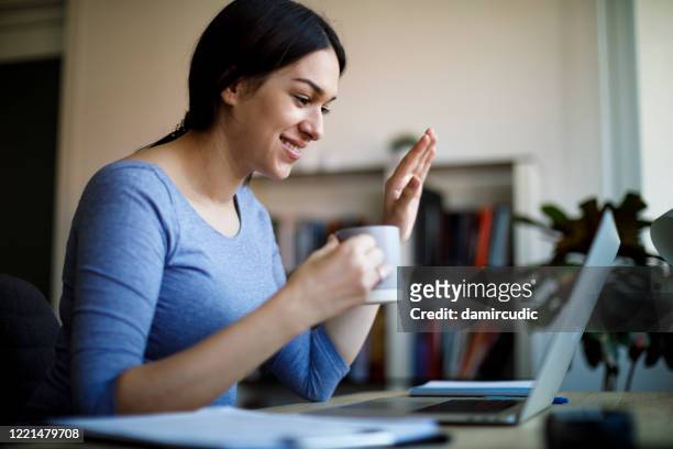 vrouw die videovraag op laptopcomputer thuis heeft - coffee chat stockfoto's en -beelden
