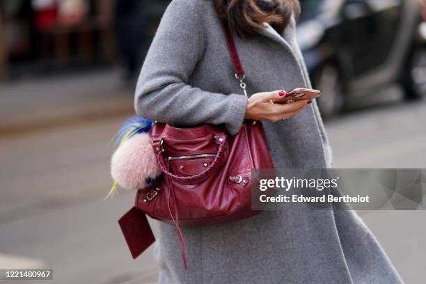 Guest wears a gray wool coat, a burgundy leather bag, outside Calcaterra, during Milan Fashion Week Fall/Winter 2020-2021, on February 19, 2020 in...