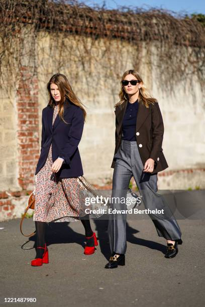 Monica de La Villardiere wears a dark navy blue blazer jacket, a floral print dress, tights, red platform shoes ; Camille Charriere wears sunglasses,...