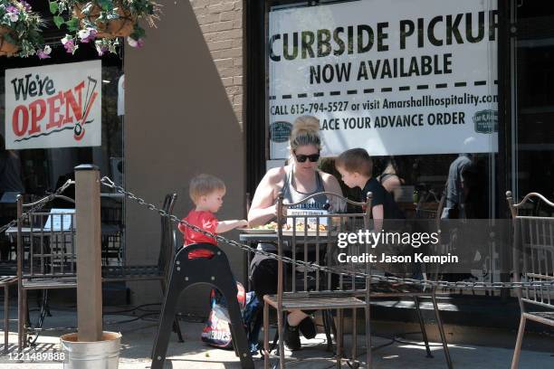 Mother and her children wait for their food at Puckett's Grocery & Restaurant on April 27, 2020 in Franklin, Tennessee. Tennessee is one of the first...