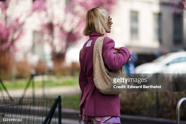 Viktoria Rader wears hair pins, sunglasses, a pink wool jacket, a Bottega Veneta woven leather bag, outside Koche x Pucci, during Milan Fashion Week...