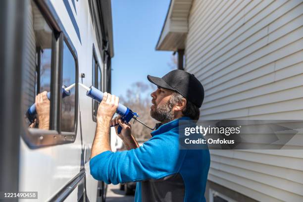 hombre haciendo mantenimiento de camper trailer - mobile home restoration fotografías e imágenes de stock