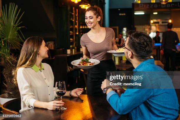 ung servitris som serverar ungt par på restaurangen - waitress bildbanksfoton och bilder