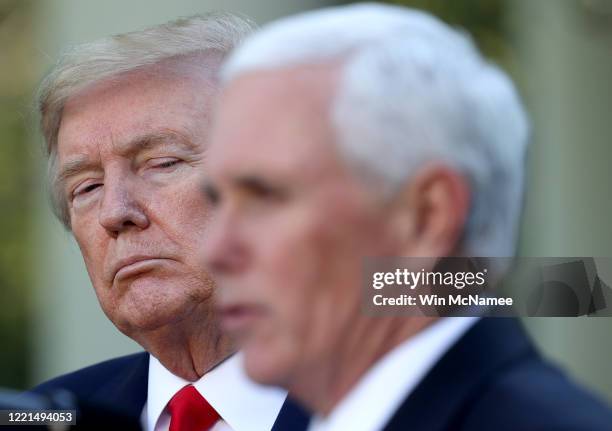 President Donald Trump listens as Vice president Mike Pence answers questions during the daily briefing of the coronavirus task force in the Rose...