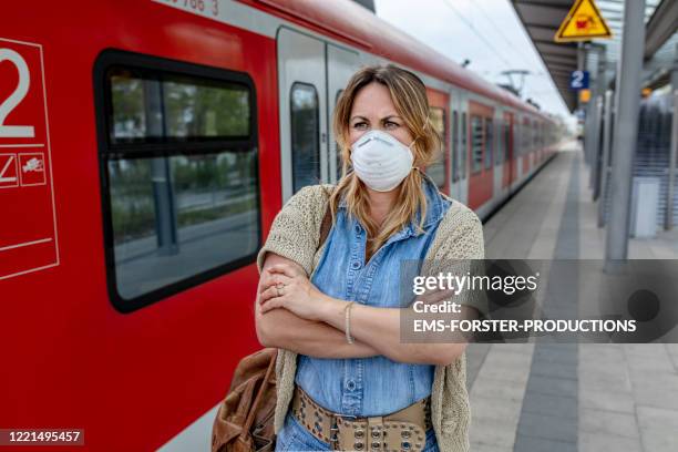 depressed woman wearing ffp-2 protective mask waiting on a s-bahn station in munich - atemmaske stock-fotos und bilder