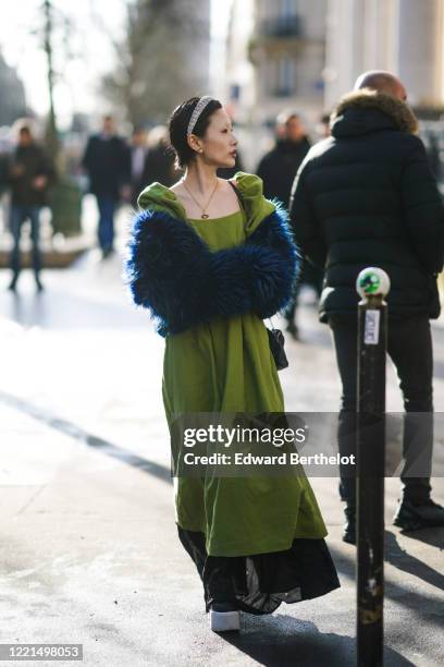 Guest wears earrings, a rhinestone headband, a necklace, a pistachio-green square neck flowing dress with puff sleeves and a black hem, a deep blue...