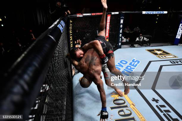 In this handout image provided by UFC, Clay Guida takes down Bobby Green in their lightweight bout during the UFC Fight Night event at UFC APEX on...
