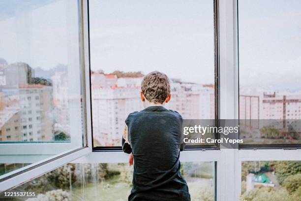 back view teenager male looking out thw window - one teenage boy only stock pictures, royalty-free photos & images