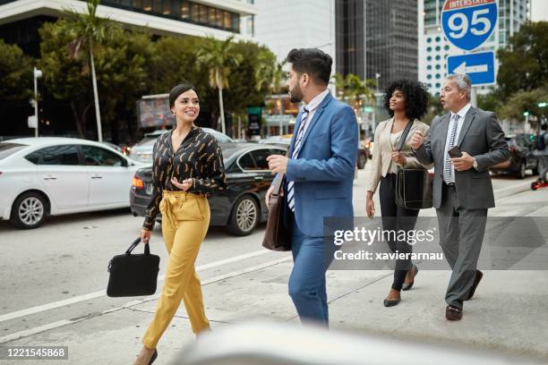 young hispanic businesswoman discussing ideas with colleague - miami business imagens e fotografias de stock