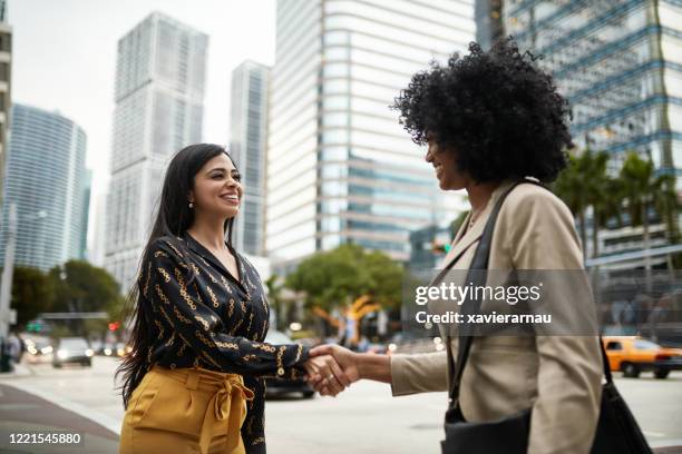 young miami businesswomen meeting and shaking hands outdoors - miami business imagens e fotografias de stock