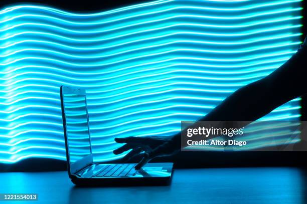 bandwidth: man's hand writing on a laptop in a futuristic environment with blue lines. - search engine stock-fotos und bilder