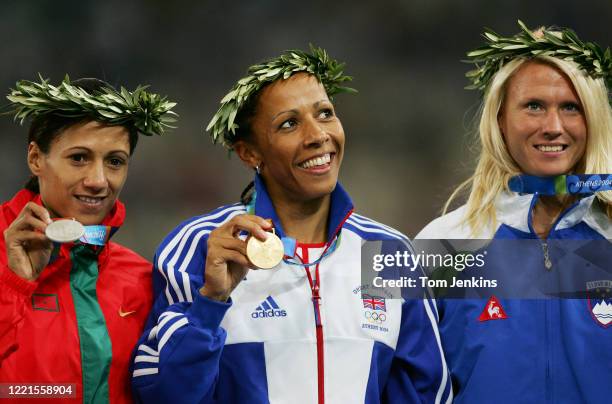 Kelly Holmes of Great Britain shows off her gold medal after she won the final of the women's 800m at the Olympic Stadium during day ten of the 2004...