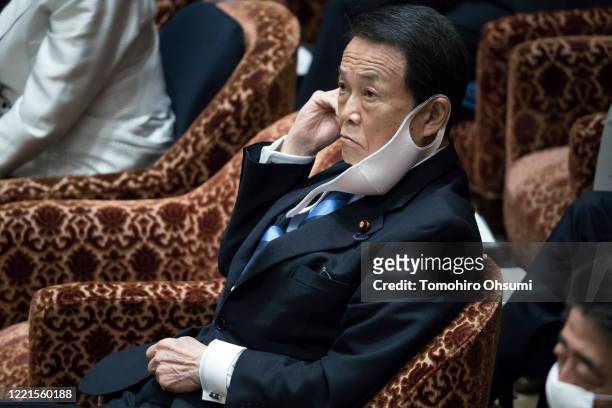 Japan's Deputy Prime Minister and Finance Minister Taro Aso wearing a face mask attends a budget committee meeting at the lower house of parliament...