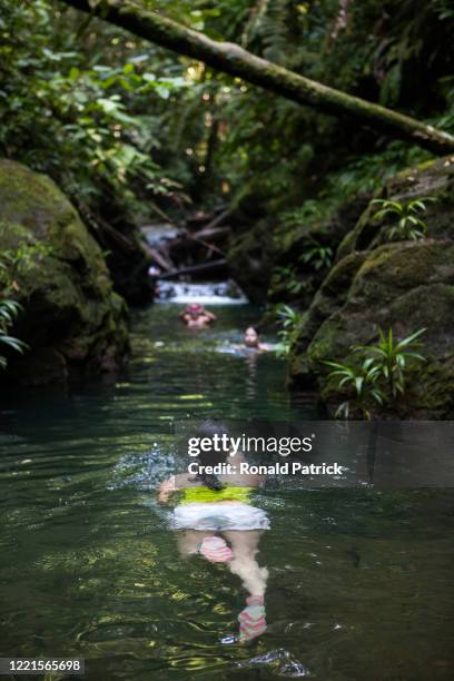 Woman swims in a small river in the warm waters of the rainforest on October 1, 2012 in Utria National Park, Colombia. The Utria National Park lies...