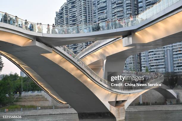 People walk on the Wuchazi Bridge, which is designed with the concept of 'Mobius Strip' on April 27, 2020 in Chengdu, Sichuan Province of China.