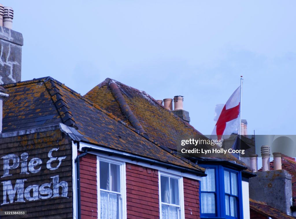 Pie and Mash sign on a wall of traditional British building with English flag.