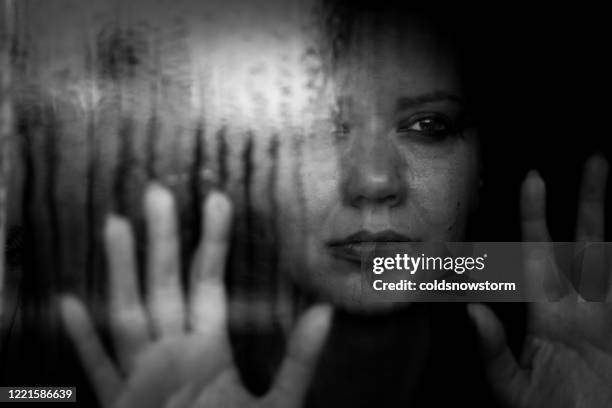 depressed woman looking out of rainy window - caught in rain stock pictures, royalty-free photos & images