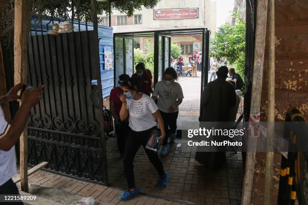 Students exit from the examination committee through sterilization gates during the first day of high school exams in Giza Governorate, Egypt, on...