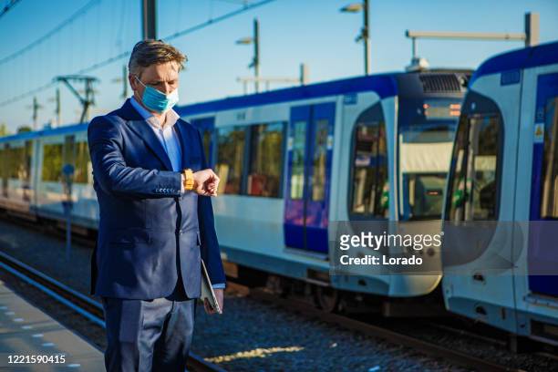a businessman at a european train station during virus outbreak - covid commuter stock pictures, royalty-free photos & images