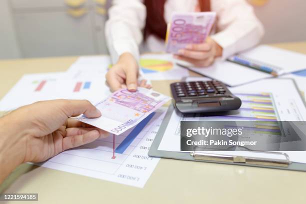 woman giving money to a man in the office. - women euro 2017 stock-fotos und bilder