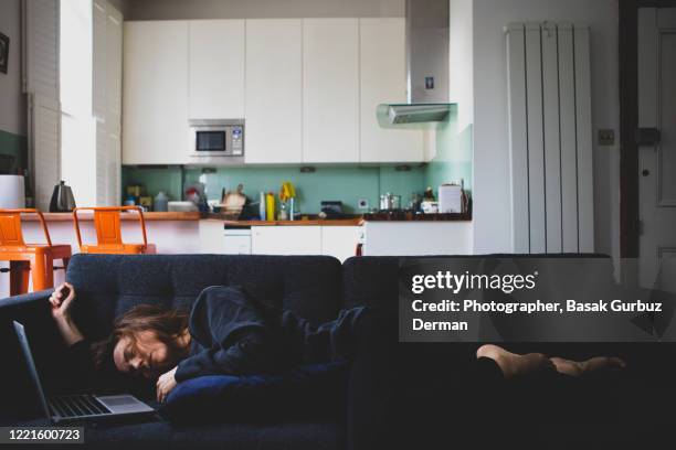 a woman lying down on a sofa, sleeping - woman taking a nap stock-fotos und bilder