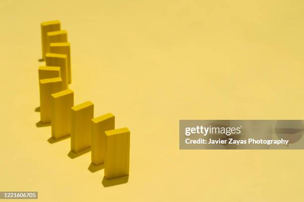 yellow dominoes on table - domino effect stock pictures, royalty-free photos & images