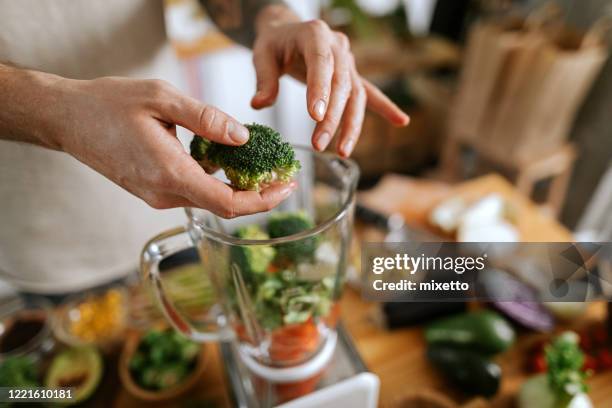 man preparing vegetable juice - liquidiser stock pictures, royalty-free photos & images