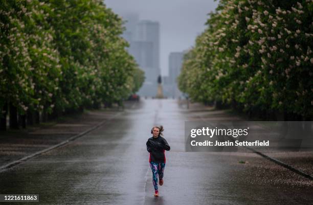 Joggers take their daily exercise in the rain at Greenwich Park on April 28, 2020 in London, England. British Prime Minister Boris Johnson, who...