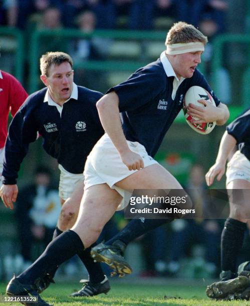 Scotland player Doddie Weir makes a run in an International match against Italy watched by scrum half Gary Armstrong on January 24, 1998 in Treviso,...