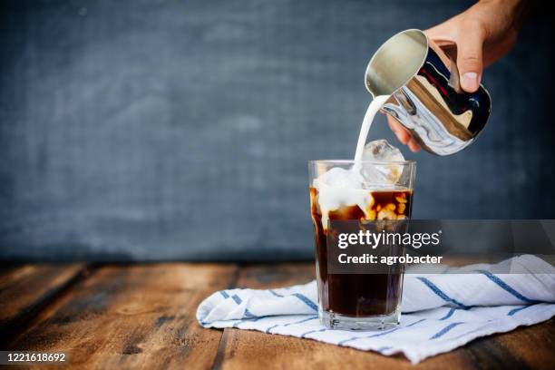 prepairing latte ghiacciato su tavolo di legno - iced coffee foto e immagini stock