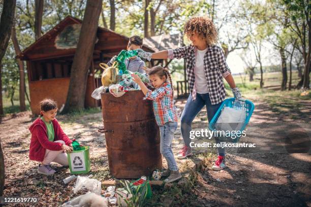 mother and kids are picking up the garbage to clean up the forest - animal volunteer stock pictures, royalty-free photos & images